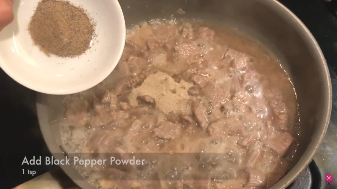 adding black pepper in the cooking beef