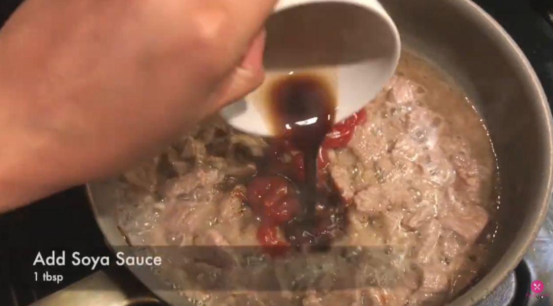 adding soya sauce in the cooking beef