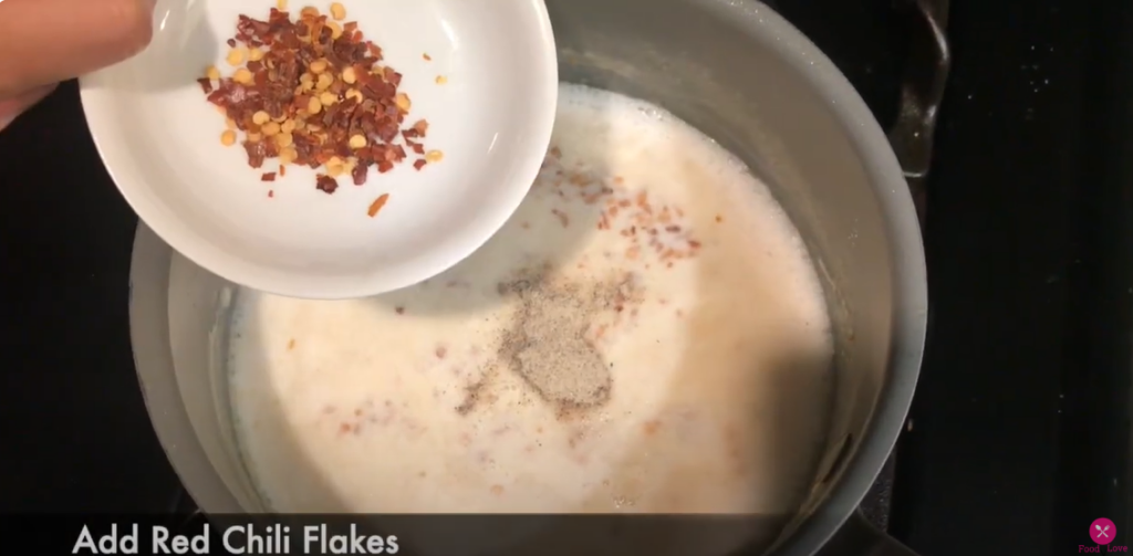 adding spices to the white sauce in the pan