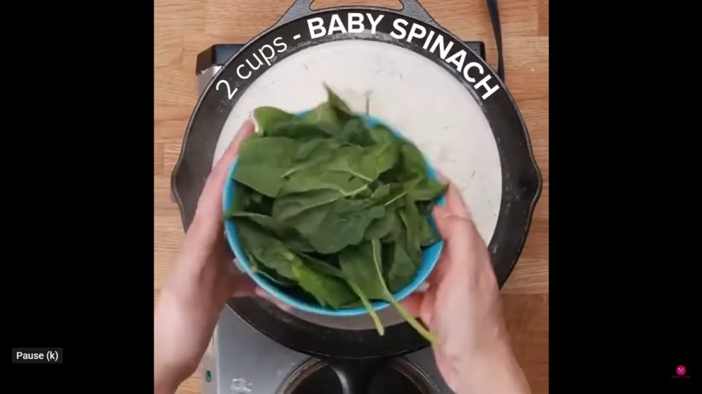 adding baby spinach in a pan