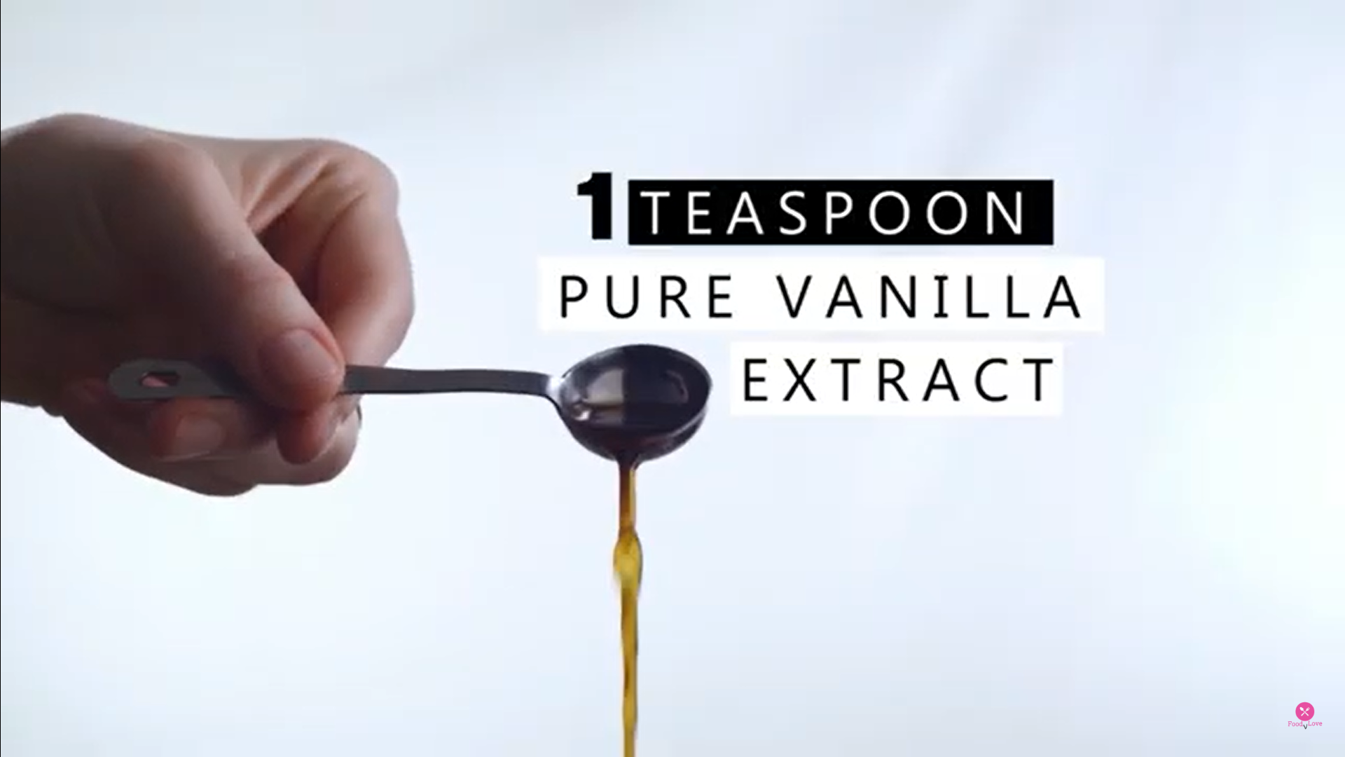 pouring vanilla extract with a spoon