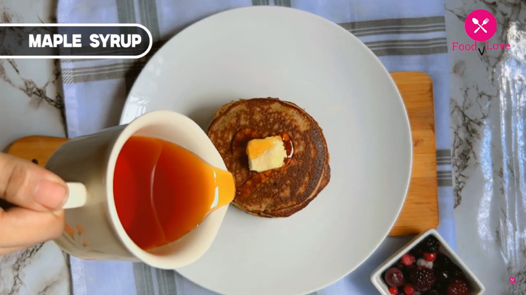 pouring maple syrup on pancakes