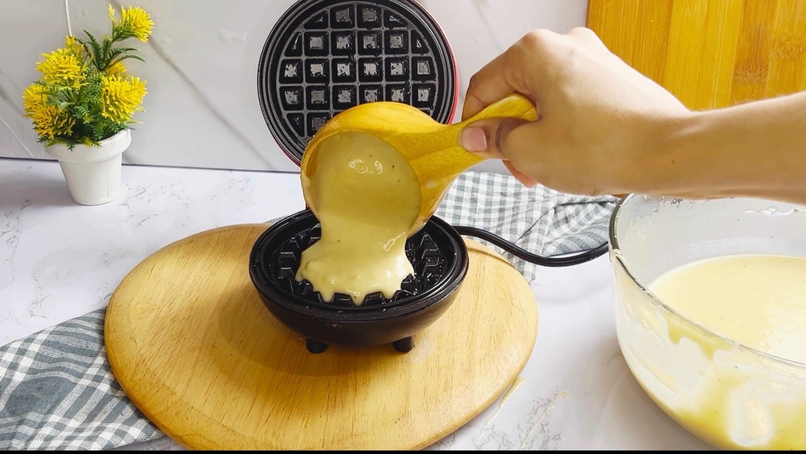 pouring the waffle batter in the waffle maker